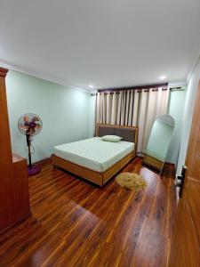 a bedroom with a bed and a fan and wooden floors at Lalitpur stay in Pātan