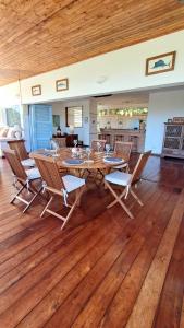 a dining room with a table and chairs on a wooden floor at Maison Orita in Nosy Be