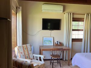 a bedroom with a chair and a desk with a tv at La Huerta in Tacoronte