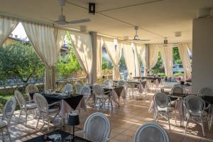 a banquet hall with tables and chairs and windows at Hotel La Carica in Pastrengo