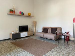 a living room with a couch and a tv at Dimora Corso Roma in Montecatini Terme