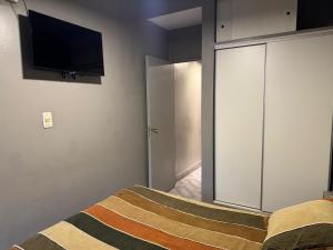 a bedroom with a bed with a tv on the wall at Danella in San Miguel de Tucumán