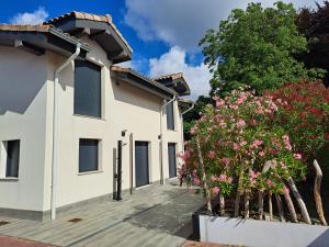 a white house with pink flowers in a yard at Hamabi in Hendaye