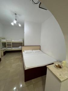 a small room with a bed and a table at Zefi Grill House in Lezhë