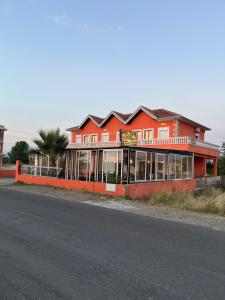 a red building on the side of a street at Zefi Grill House in Lezhë