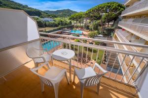 a balcony with a table and chairs and a pool at Hotel President in Calella