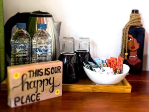 a sign that says this is our happy place on a table with drinks at Rhythm Beach in Trincomalee