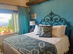 a blue bedroom with a bed and a window at El Encanto Posada & Spa in Sabana Grande