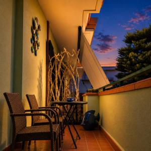 a balcony with chairs and a table and a staircase at UTOPIA "The Art of Bed & Breakfast" in Marigliano