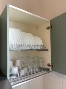 a shelf with glass vases and plates in a kitchen at Dimora Corso Roma in Montecatini Terme