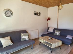 a living room with two couches and a coffee table at Maisonnette cosy au calme avec jardin clos - Puy dufou in La Ronde