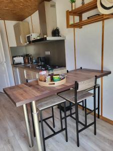 a kitchen with a wooden table and two chairs at Maisonnette cosy au calme avec jardin clos - Puy dufou in La Ronde