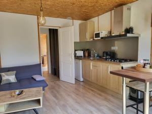 a kitchen with wooden cabinets and a table and a counter at Maisonnette cosy au calme avec jardin clos - Puy dufou in La Ronde
