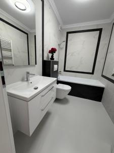 a white bathroom with a sink and a toilet at Best Luxury Residence in Bistriţa +34 photos