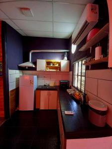 a kitchen with a white refrigerator and a black counter top at Casa Petricor in Río Tercero +6 photos
