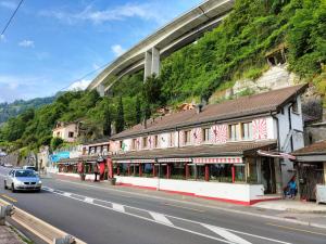a building on a street with a bridge in the background at Chillon lake view by MK in Montreux