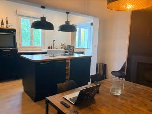a kitchen with a table with a laptop on it at logement tranquille avec jardin in Saint-Germain-et-Mons