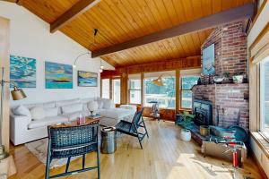 a living room with a couch and a fireplace at Stunning artist's retreat with ocean view & amazing deck, near Reid State Park in Georgetown