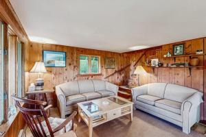 a living room with two couches and a table at Peaceful coastal cabin with screened porch, water view of the cove, dog-friendly in Owls Head