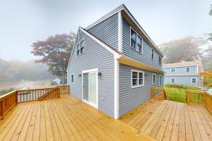 a large deck with a house on top of it at Boothbay Harbor Home with Water Views | Near Dining & Whale Watching in Boothbay Harbor