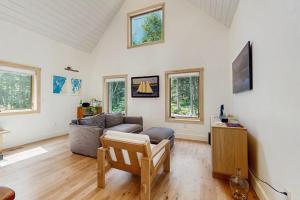 a living room with a couch and a tv at Charming New Home with Hot Tub, Spacious Deck, Gas Grill, WiFi, and Washer/Dryer in Boothbay