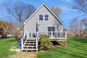 a white house with a porch and a house at Dog-friendly home with deck, pool table, & firepit - walk to downtown Boothbay in Boothbay Harbor