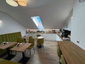 a restaurant with tables and chairs and a kitchen at VILLA SOLARIS Ustka - PENSJONAT Z 2026R,ROWERY GRATIS, WYPOCZYNEK tylko DLA DOROSŁYCH ! in Ustka