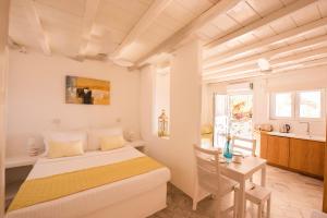 a white bedroom with a bed and a table at Eagles Nest Mykonos Suites & Apartments - Shared Pool & Jacuzzis in Mikonos +168 photos