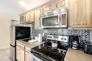 a kitchen with a stove and a microwave at Water-view condo at Sheepscot Harbour Resort with deck, full kitchen, and WiFi in Edgecomb