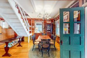 a dining room with a table and chairs and a staircase at Cozy, Waterfront Cabin-Style Gem with Private Dock and Lovely Views in East Harpswell