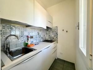 a kitchen with white cabinets and a sink at Colibrì by SolturElba in Capoliveri +68 photos