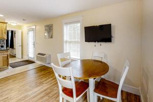 a dining room with a table and chairs and a television at New Riverfront Condo in Sheepscot Harbour - Walk to Famed Seafood Eatery in Edgecomb