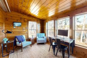 a dining room with a table and chairs and windows at Gorgeous Waterfront Home on Westport Island with 2 Sunrooms in Montsweag
