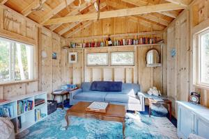 a living room with a blue couch and a table at Charming Boothbay Harbor cottage with partial AC, full kitchen, and sun room in Boothbay Harbor