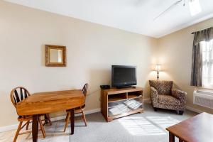 a living room with a table and a tv and a chair at Comfortable Suite in Downtown Northeast Harbor w/ WiFi & AC - Walk to the Water in Northeast Harbor