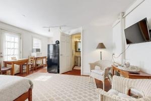 a kitchen and living room with a black refrigerator at Downtown, ground floor studio near the ocean w/patio, outdoor dining area & more in Wiscasset