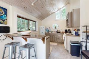 a kitchen with a counter and two stools in it at Geodesic Dome w/ Riverfront Deck, Lovely Views, & High-Speed WiFi - Dogs Welcome in Boothbay