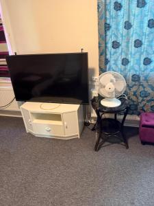 a flat screen tv in a room with a fan at YKI Room in Oulu
