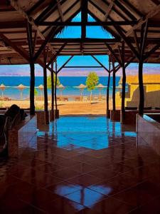 a pavilion with a view of a beach with umbrellas at Sina life camp in Nuweiba
