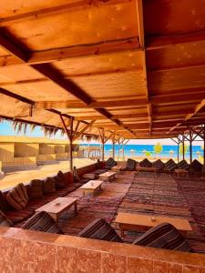 a pavilion with tables and chairs on a beach at Sina life camp in Nuweiba