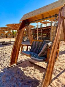 a chair in a swing on the beach at Sina life camp in Nuweiba