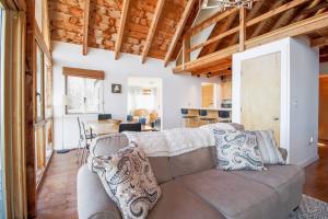 a living room with a couch and a kitchen at Remodeled Waterfront Home with Wraparound Deck, Water Views, & Beach Access in Waldoboro +22 photos