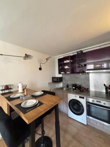 a kitchen with a wooden table in a kitchen at La nuit calme in Annemasse