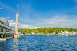 a sailboat is docked in a body of water at Amazing All-Season Sprucewold Cabin w/ Private Beach Club Access Dog-friendly in Boothbay Harbor