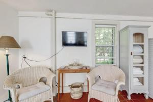 two chairs in a room with a table and a tv at Downtown, ground floor studio near the ocean w/patio, outdoor dining area & more in Wiscasset