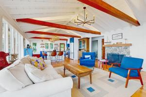 a living room with a white couch and blue chairs at 2 Waterfront Cottages in Ocean Point with Dock & Large Yard, Dog friendly in East Boothbay