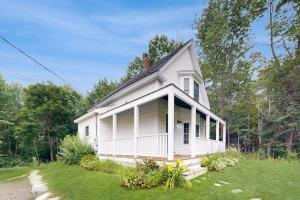 a small white house with a grass yard at Charming Camden Retreat with Front Porch, Deck and Wifi in Camden