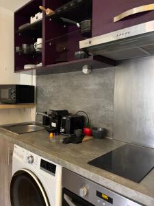 a kitchen with a washer and a washing machine at La nuit calme in Annemasse