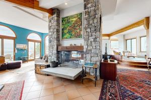 a living room with a stone fireplace in a house at Private Oceanfront Home -- 2 Fireplaces, 4 Decks & Grill, Dog-friendly in East Boothbay