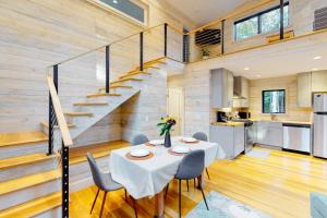 a dining room with a table and a staircase at Contemporary retreat with grill, firepit, & patio - walk to beach in Marlboro